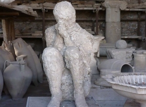 gipsafdruk van zittende persoon schuilend voor de uitbarsting van de Vesuvius in AD79in pompeii